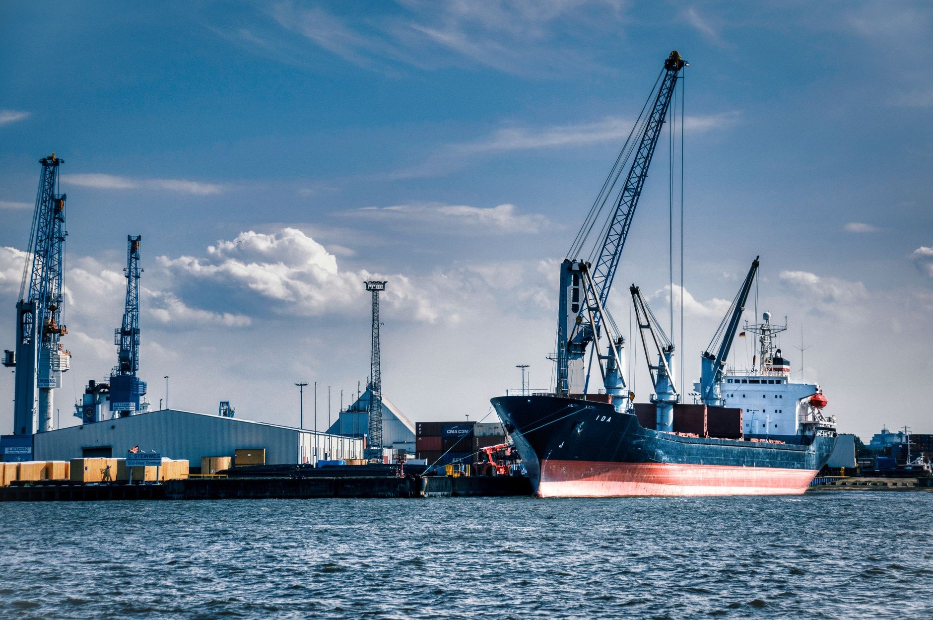 Navă de marfă încărcată cu containere într-un port activ