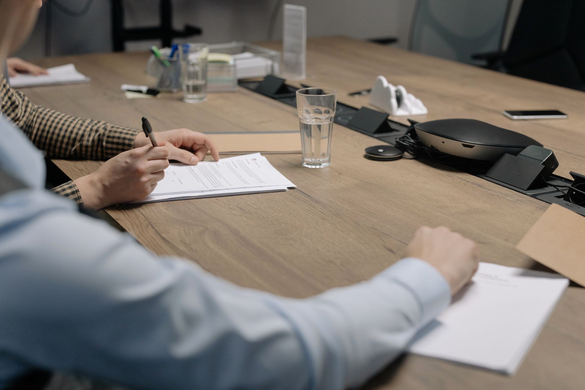 Persone che firmano documenti societari durante una riunione di consulenza